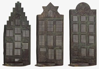 Bild av tre dekorativa ljushållare i antik mässing
