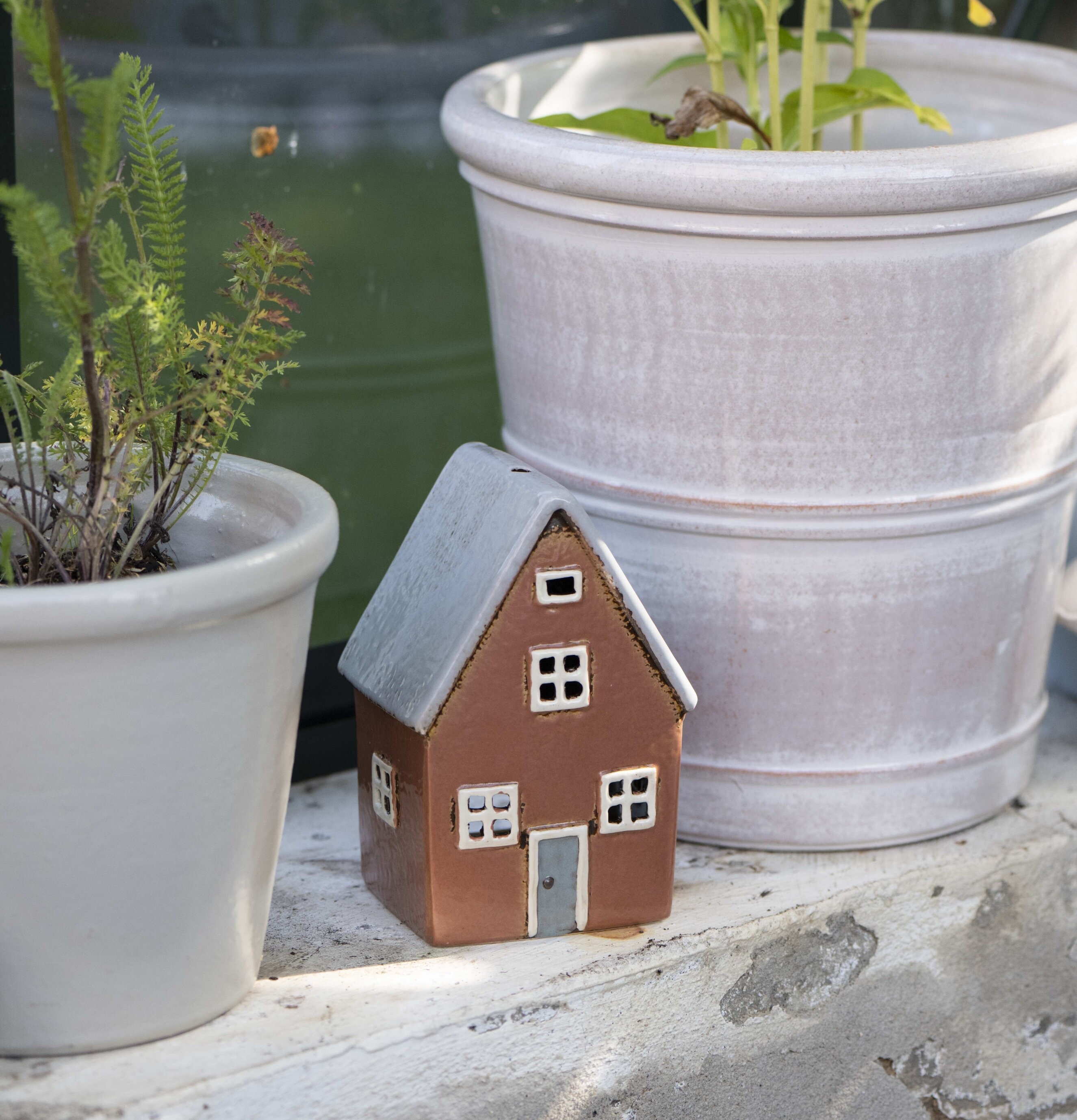Ljuslykta Nyhavn från IB Laursen på fönsterkarm med växter