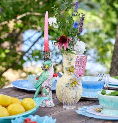 Foto av färgstark bordsmiljö med keramik och blommor