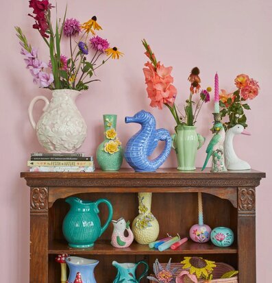 Bild av charmigt inredd hylla med keramik och färger