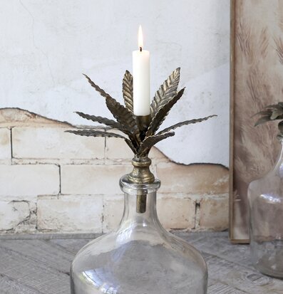 Bild av antik ljushållare i mässing på glasflaska