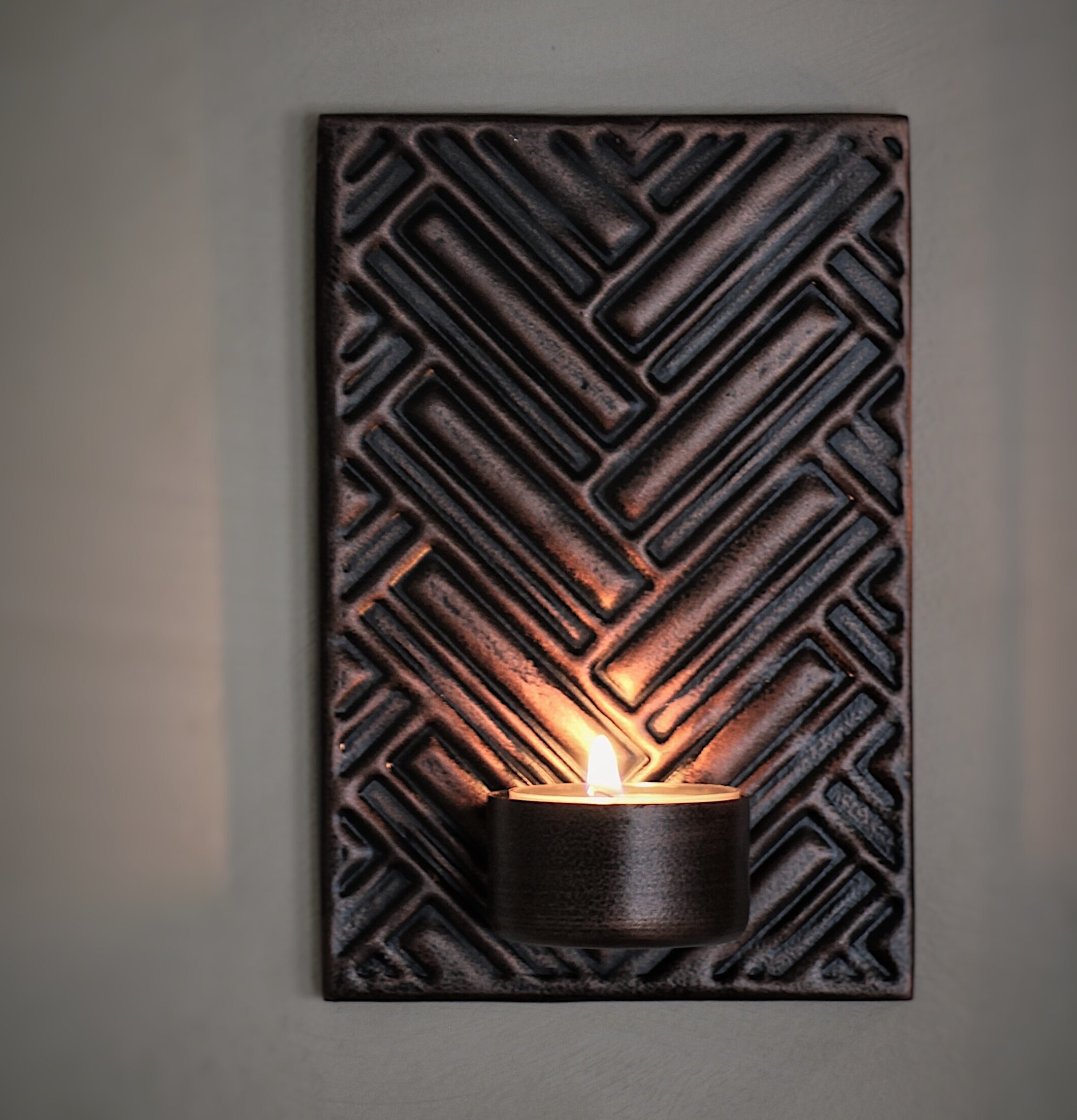 Foto av stilfull väggljushållare med herringbone-mönster
