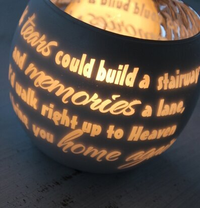 Bild av ljuslykta med mjukt ljus och ingraverat citat