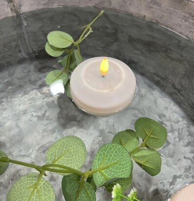 Bild av flytande ljuslykta med LED och gröna blad