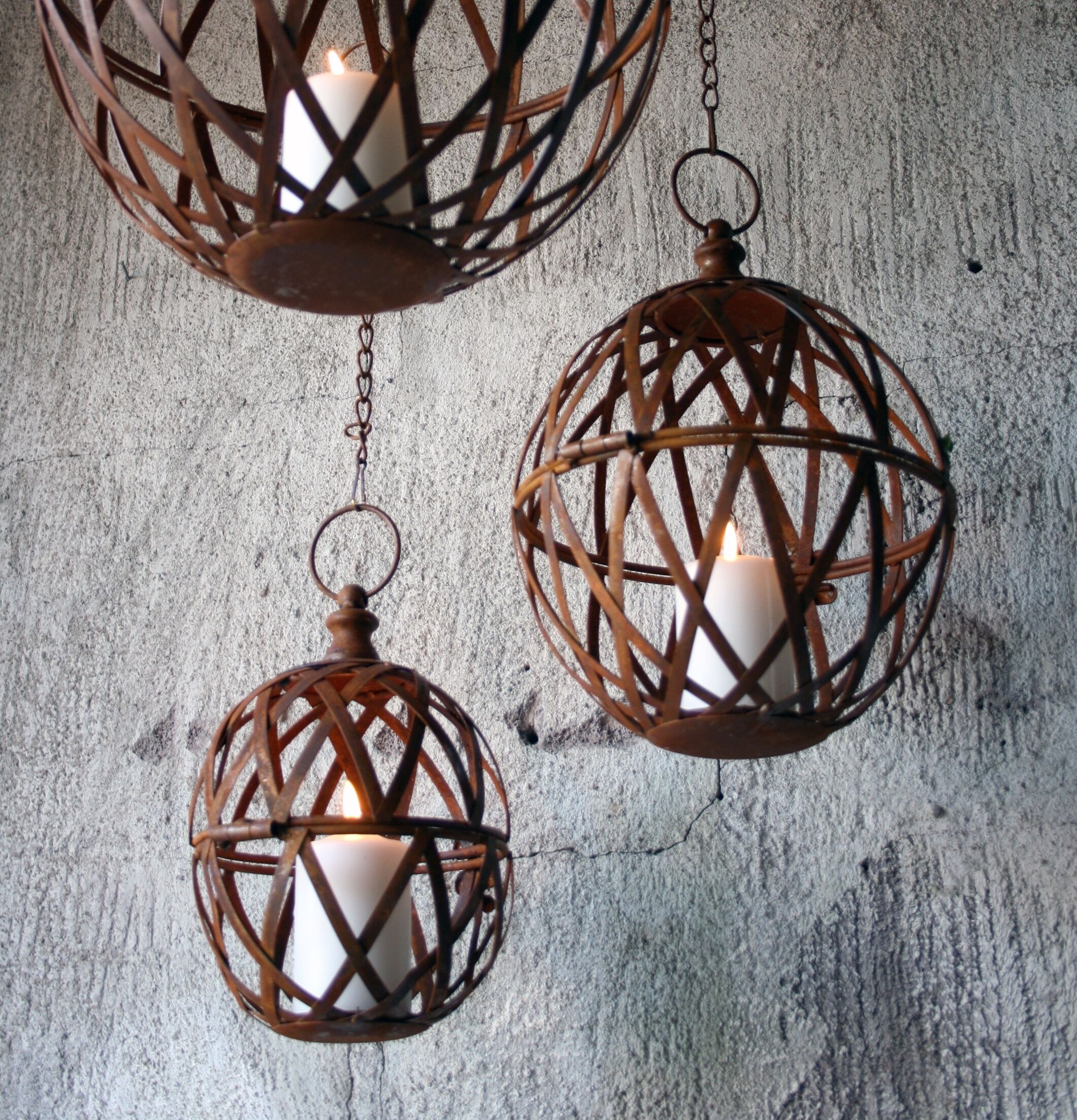 Bild av tre hängande ljusklot i rostfärgad metall