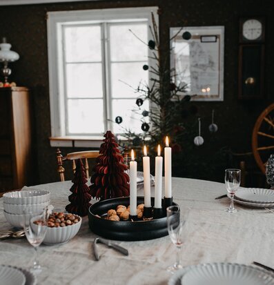 Foto av smakfullt dukat bord med ljusstake och juldekor