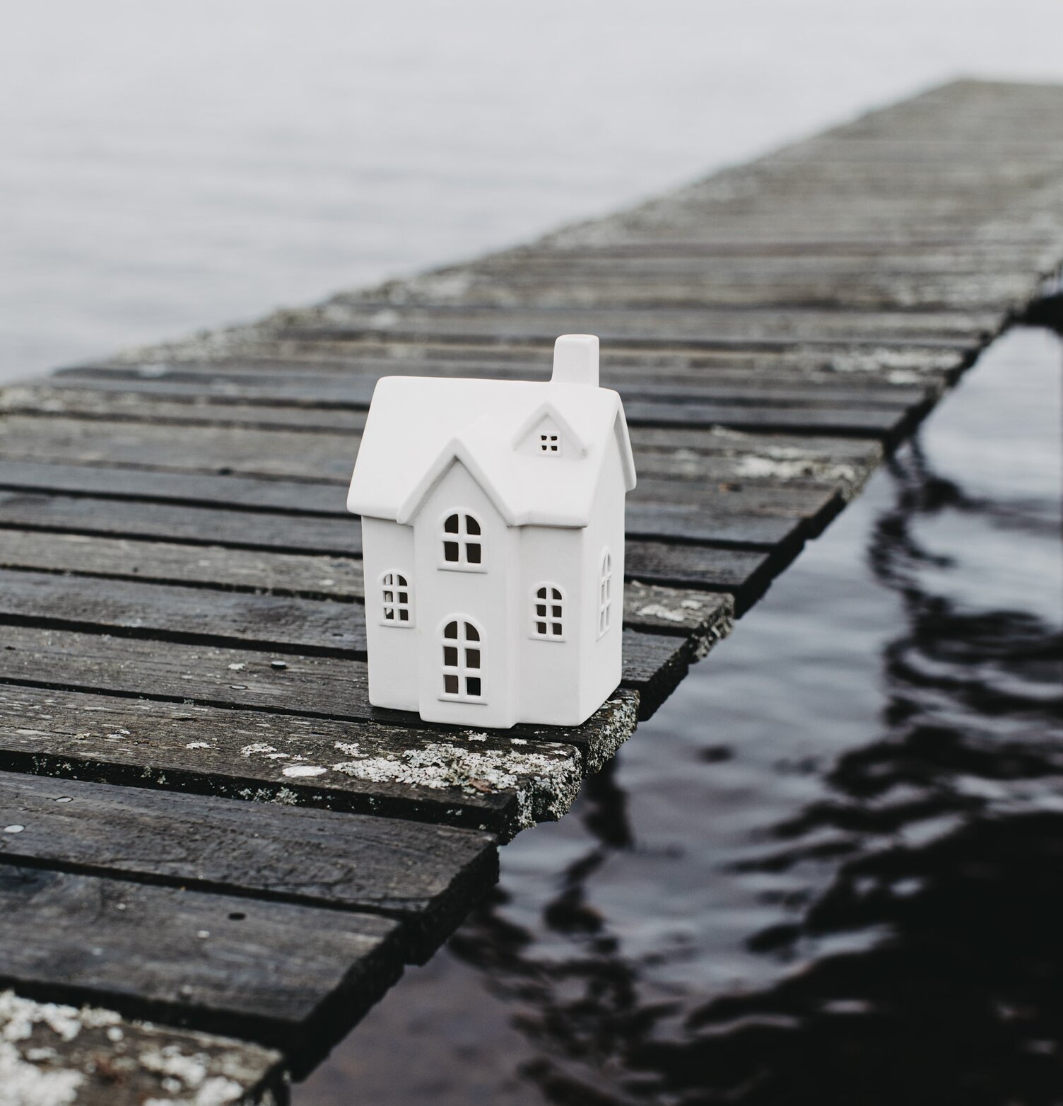 Ljusstake Hus Byn 7 från Storefactory på en rustik träbrygga