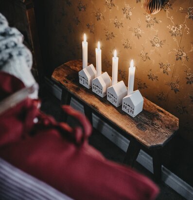 Bild av ljusstakar på rustik bänk med blommig tapet