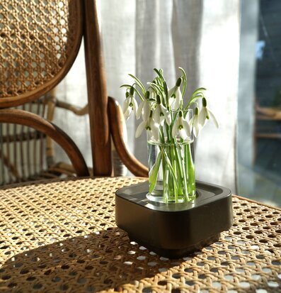 Bild av elegant ljuslykta på rottingbord med snödroppar