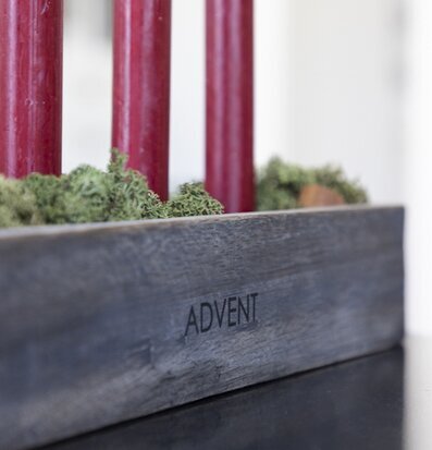 Bild av adventsljusstake med grå träbas och röd ljus