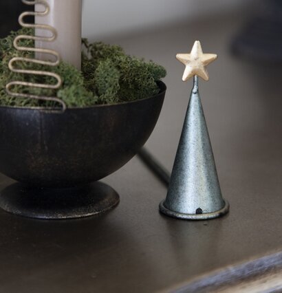 Ljussläckare Gran från Different Design bredvid ljusstake