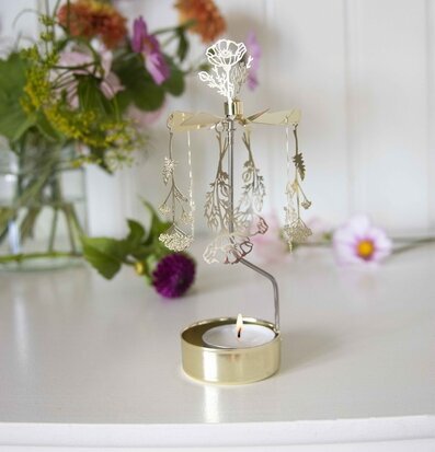 Bild av ett änglaspel med blommor och naturliga inslag