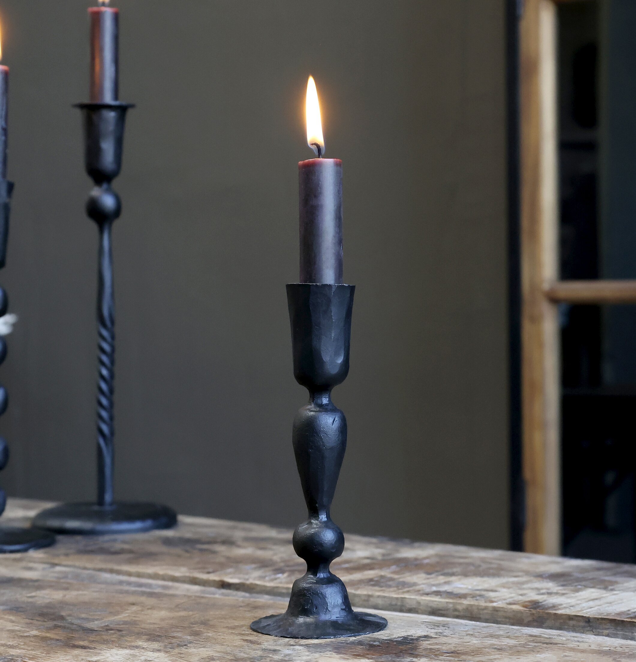 Bild av eleganta antiksvarta ljusstakar i rustik miljö