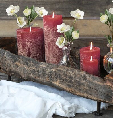 Bild av rustika mörkröda blockljus och vita blommor
