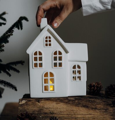 Ljusstake Hus Byn 8 från Storefactory på träyta med gran