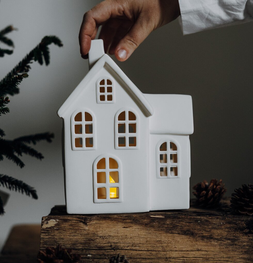 Ljusstake Hus Byn 8 från Storefactory på träyta med gran