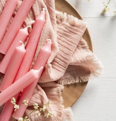 Bild av korall-rosa ljus på träbricka med blommor