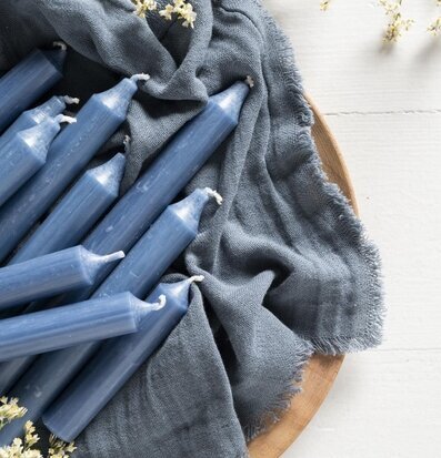 Foto av rustika blå stearinljus på träbricka