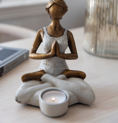 Foto av detaljrik ljushållare i meditationsställning