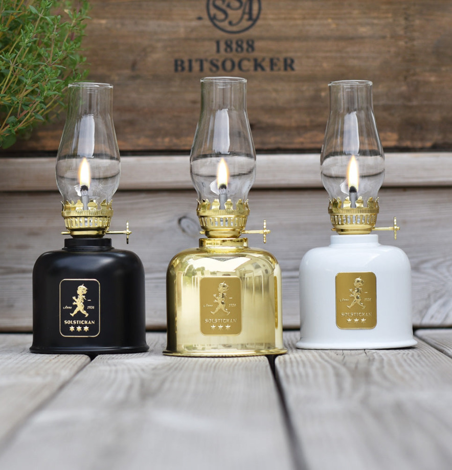 Fotogenlampa Svart/Guld från Solstickan på träplankor