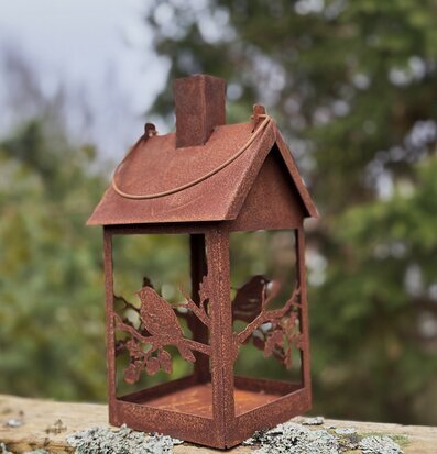 Foto av unik ljuslykta och fågelmatare i rostad metall