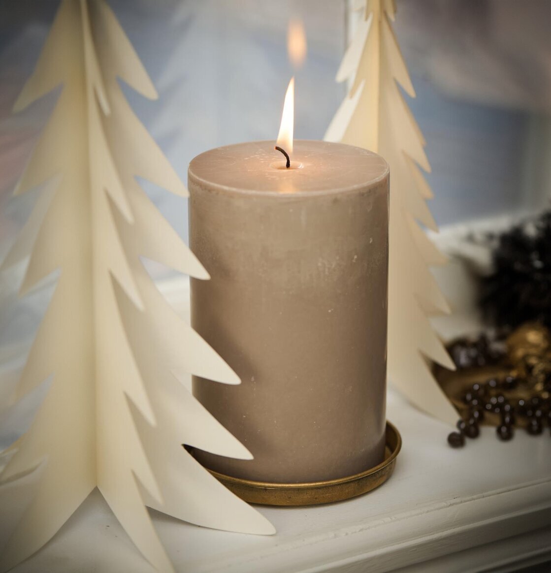 Bild av ett kyrkoljus med stilrena dekorativa granar