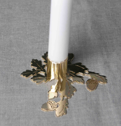 Bild av ljusstake i gyllene ton med naturinspiration