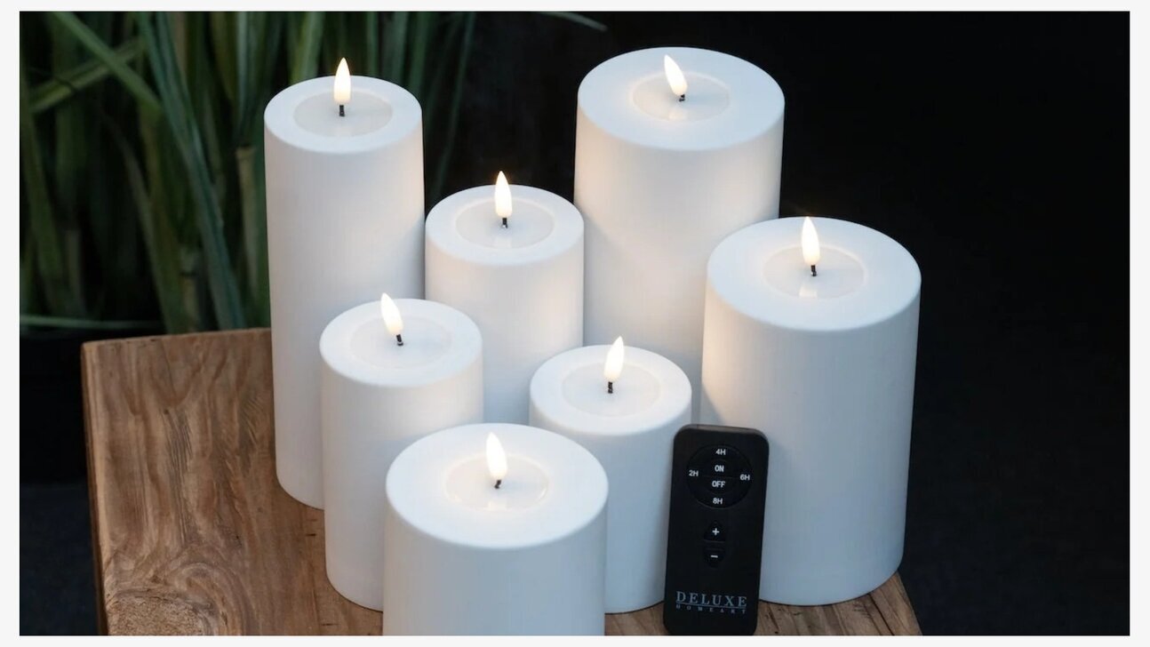 Bild av vita blockljus på träbord med fjärrkontroll