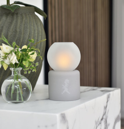 Bild av stilren ljuslykta på marmorbänk med blommor