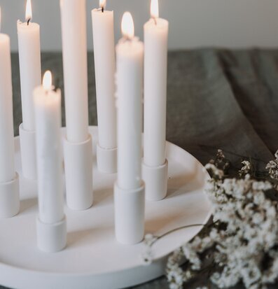 Bild av ljusfat med åtta tända ljus och vita blommor