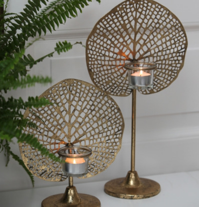 Bild av dekorativa ljushållare i guld med bladmönster