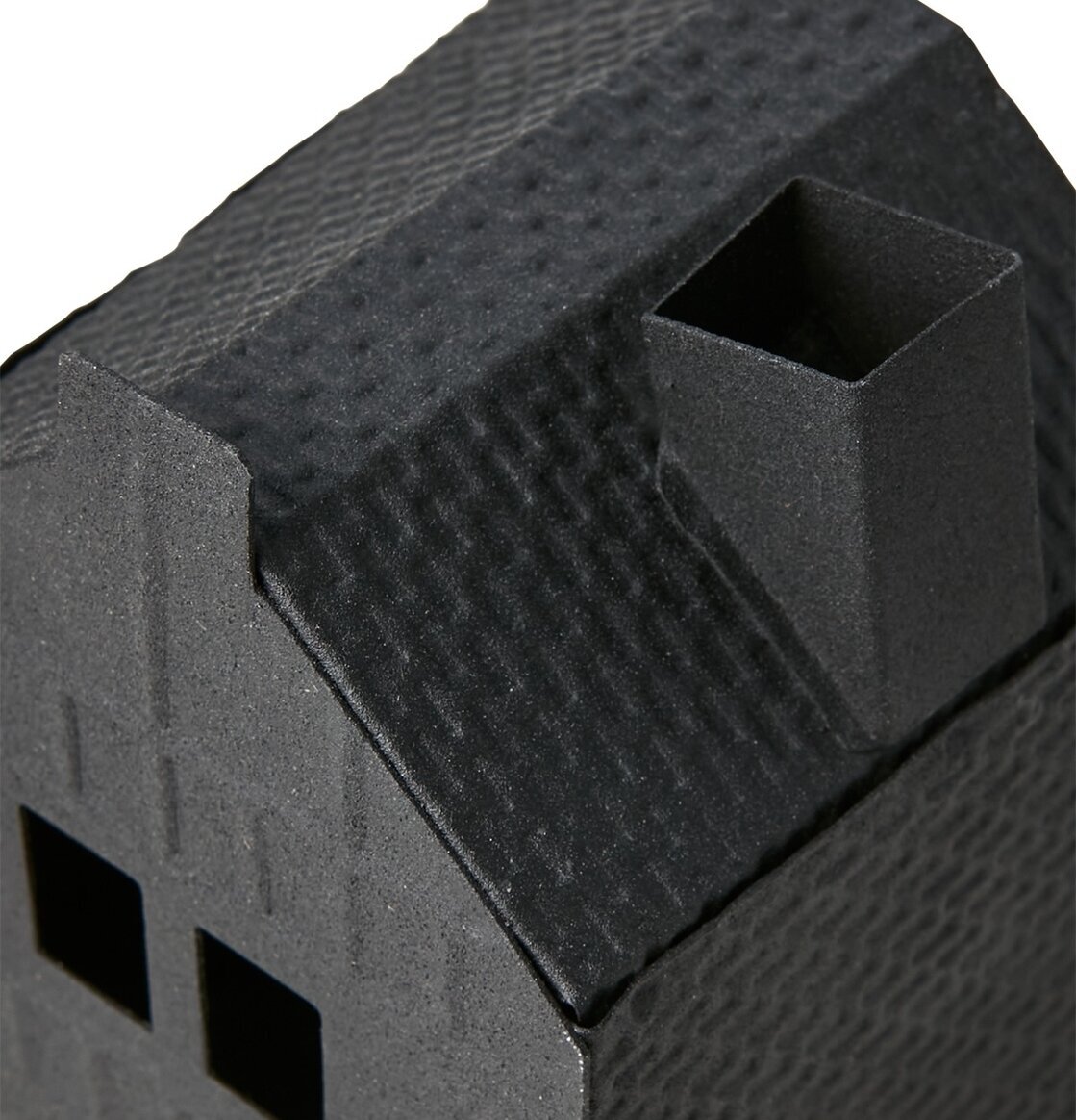 Foto av en stilren och texturerad ljuslykta som ett hus