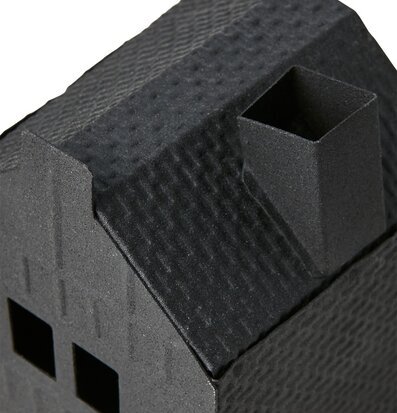 Foto av en stilren och texturerad ljuslykta som ett hus