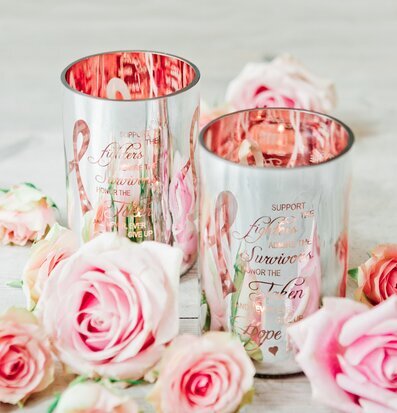 Bild av silvriga ljuslyktor med rosa band och rosor