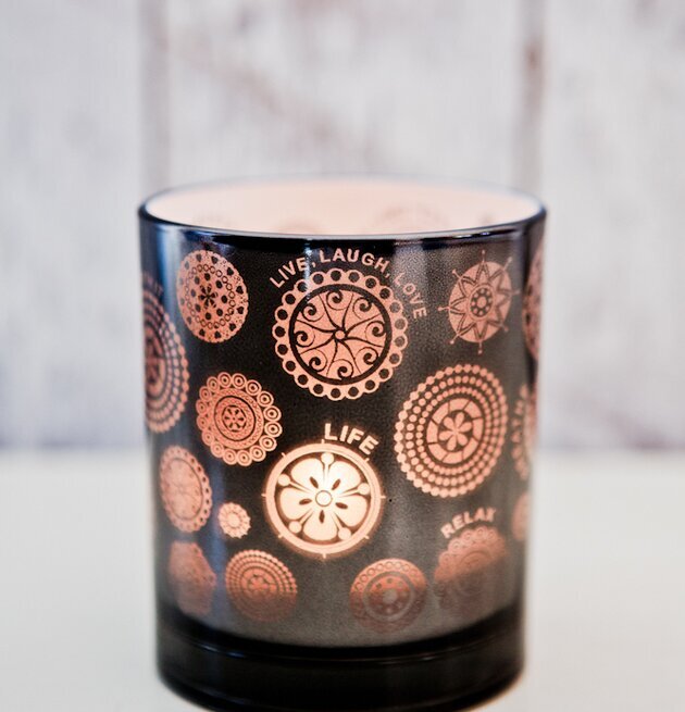 Bild av röktonad ljuslykta med kopparfärgade mönster