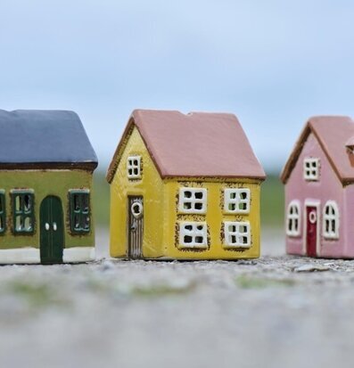 Bild av tre charmiga husformade ljuslyktor i olika färger