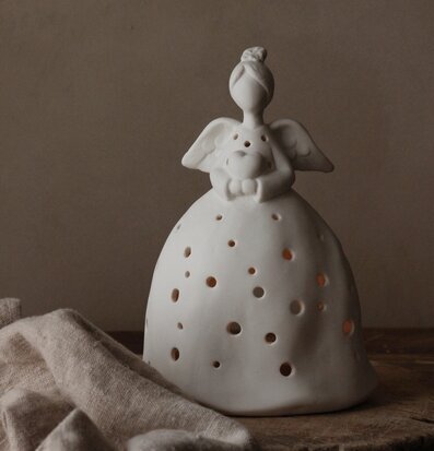 Bild av keramikängel med ljus och perforerade detaljer