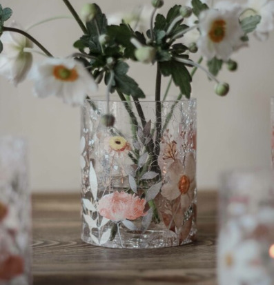 Foto av glasljuslykta med blommönster och varm atmosfär