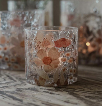 Bild av ljuslykta med blommotiv och jordnära toner