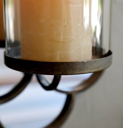 Bild av väggspegel med ljusstake och tänd glaslykta