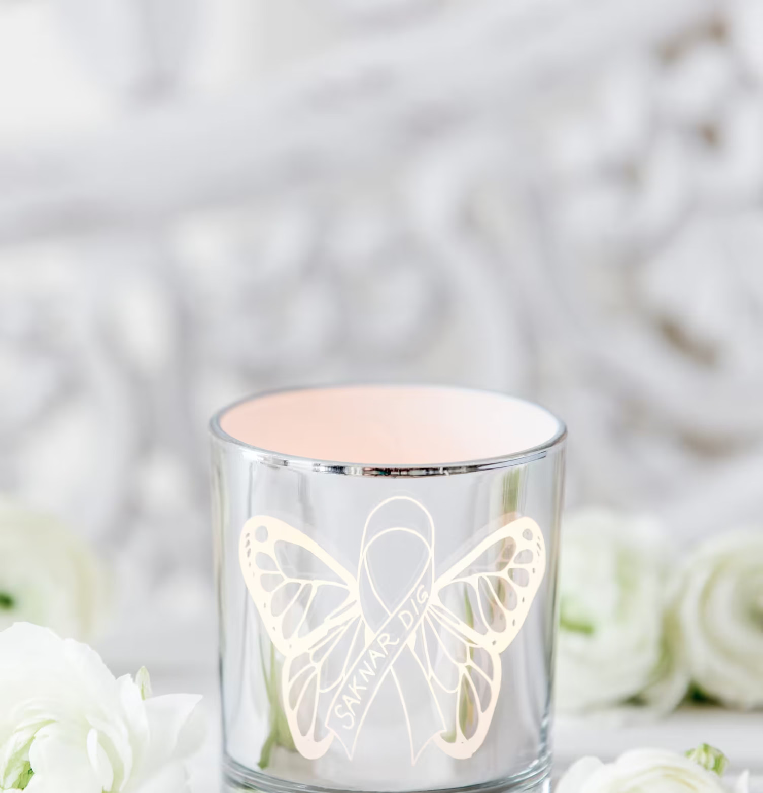 Bild av ljuslykta med fjärilsmotiv och vita blommor