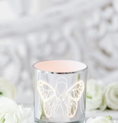 Bild av ljuslykta med fjärilsmotiv och vita blommor