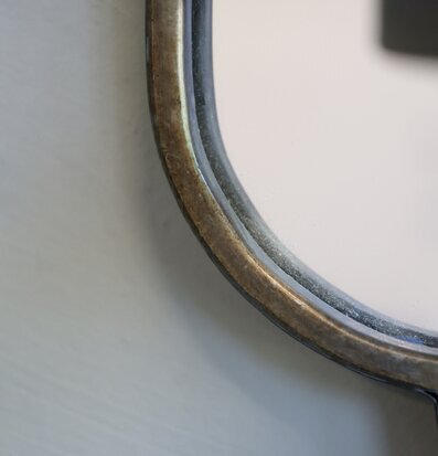 Bild av spegel med ljusstake och rustik metallpatina