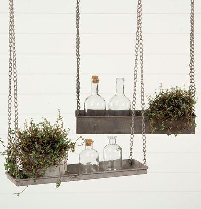 Foto av hängande hyllor i metall med växter och glasflaskor