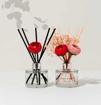 Bild av eleganta diffuserflaskor med blommor och pinnar