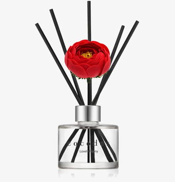 Foto av stilren ljuslykta med doftpinnar och pion