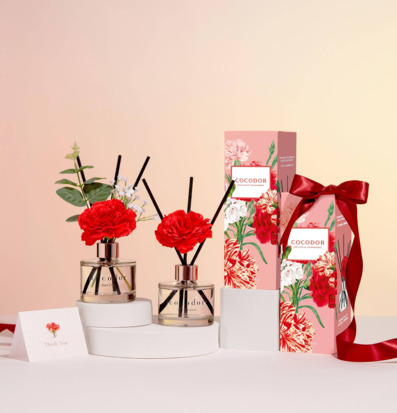 Bild av elegant doftuppställning med nejlikor och blommor