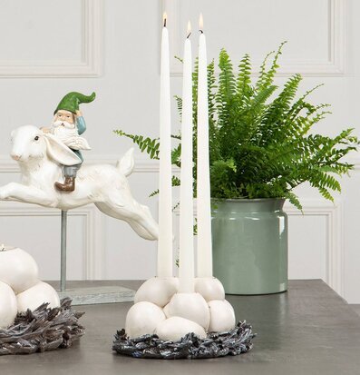 Bild av ljusstake med antik finish och grön växtlighet