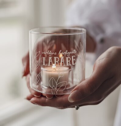 Bild på glaslykta med text och värmeljus – stilren dekoration