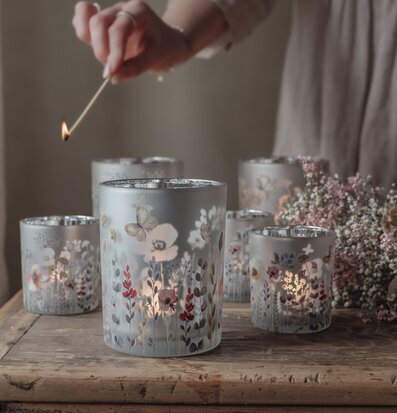 Bild av stämningsfulla ljuslyktor med blommotiv på träbord